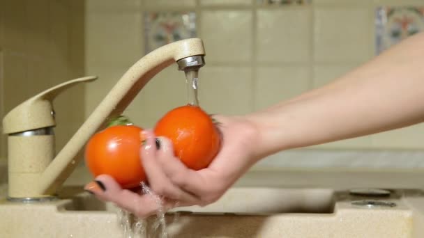 Vrouw wast haar handen tomaten — Stockvideo