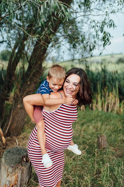 Mujer embarazada abrazándose con su hijo . —  Fotos de Stock