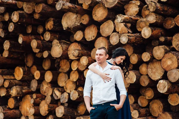 Casal feliz no amor de pé perto de logs — Fotografia de Stock