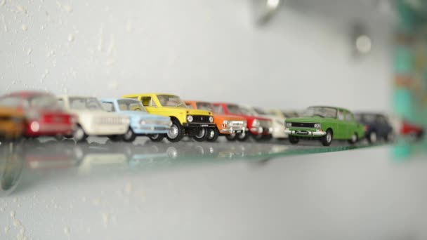 Colección de coches de juguete en el estante de cristal. cámara enfoque se mueve en los coches — Vídeo de stock