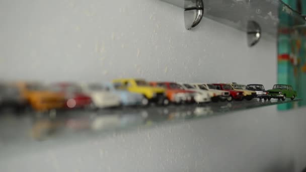 Collection of toy cars on the glass shelf. camera focus moves on cars — Stock Video