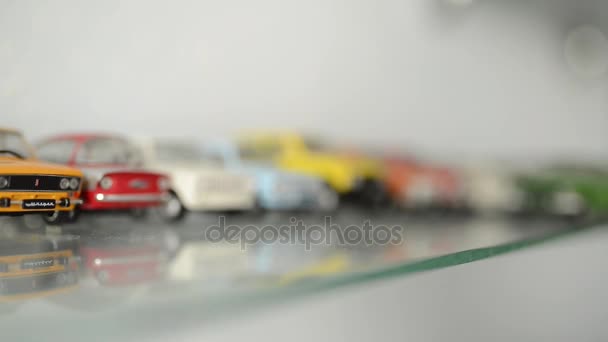 Collection of toy cars on the glass shelf. camera focus moves on cars — Stock Video