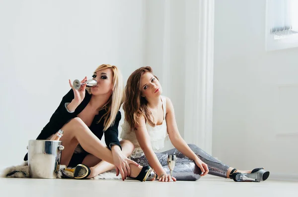 Красивые девушки пьют вино на полу — стоковое фото