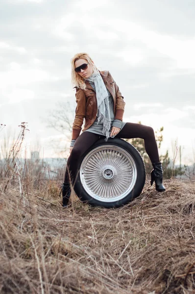 섹시 한 젊은 여자는 큰 바퀴에 앉아 — 스톡 사진