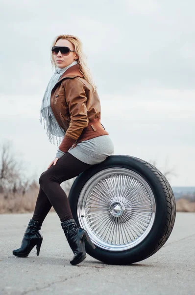 Сексуальная молодая девушка сидит на большом колесе — стоковое фото