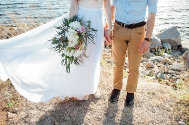 Düğün. damat ve gelin buketi tutuyor