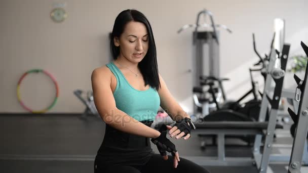 Hermosa chica deportiva se pone guantes en la mano — Vídeos de Stock