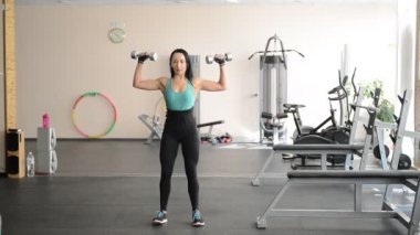 güzel kız dumbbells ile egzersizleri yapıyor uygun