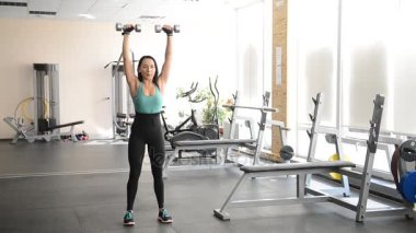 güzel kız dumbbells ile egzersizleri yapıyor uygun