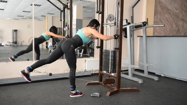 Schattig fit meisje doet oefeningen op de simulator — Stockvideo