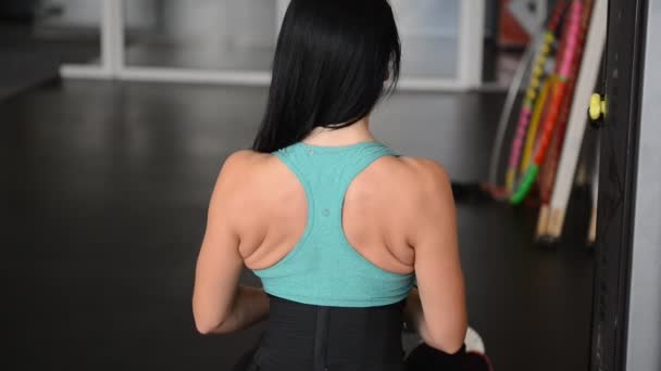 Симпатичная подтянутая девушка делает упражнения на тренажере — стоковое видео