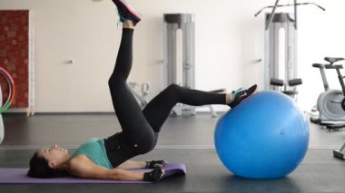 Spor kız egzersizleri ile topu yere gerçekleştirir.