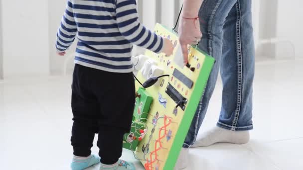 ひたすら忙しいボードとのプレイの小さな男の子 — ストック動画
