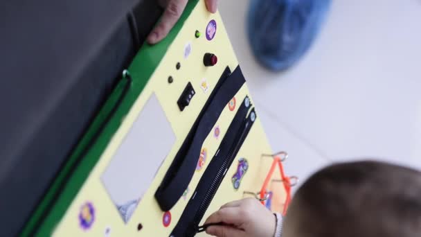 Pequeño bebé jugando intensamente con tablero ocupado — Vídeos de Stock