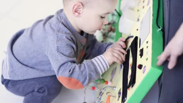 Kleiner Junge spielt eifrig mit besetztem Brett — Stockvideo
