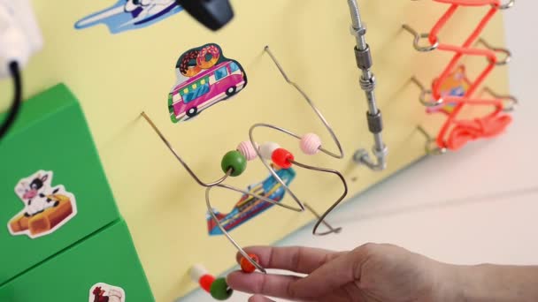 Little baby boy intently playing with busy board — Stock Video