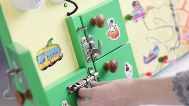 Little baby boy intently playing with busy board — Stock Video