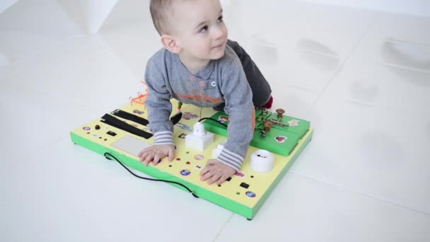 Pequeno menino brincando intensamente com o tabuleiro ocupado — Vídeo de Stock