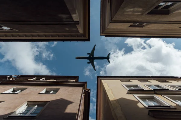 Avion de passagers survolant les toits de maisons résidentielles, vols à basse altitude, transport — Photo