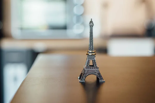 Trauringe auf einer Eiffelturmstatue auf einem Holztisch — Stockfoto