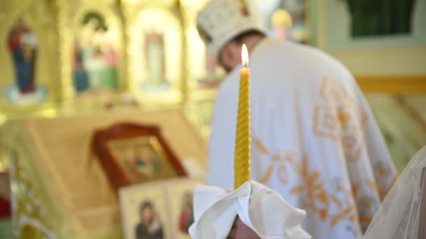 Den ortodoxa prästen står i kyrkan och håller ett kors i sina händer — Stockvideo