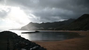 Altın kumun, palmiye ağaçlarının, güneş panjurlarının tepesinden bak. bulutlu hava