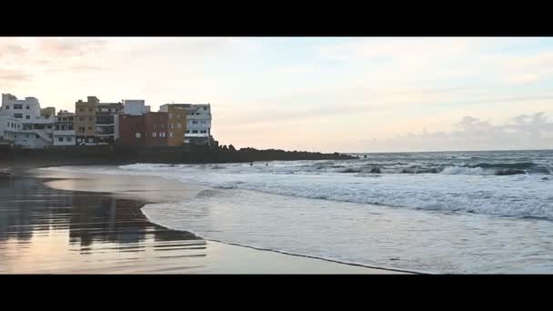 Fantásticamente hermosa puesta de sol en la costa norte de Tenerife, una playa con piedras y arena negra . — Vídeos de Stock