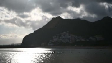 Tenerife sahilinde yağmur, bulutlu havada dağ arkası..