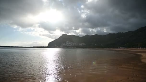 Lluvia en la playa de Tenerife con fondo de montaña en tiempo nublado . — Vídeo de stock