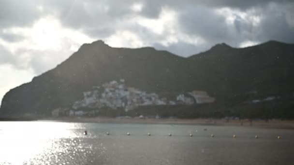 Lluvia en la playa de Tenerife con fondo de montaña en tiempo nublado . — Vídeo de stock