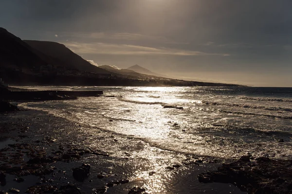 Flight above ocean waves facing beautiful sunset and mountains on horizon. — Stock Photo, Image