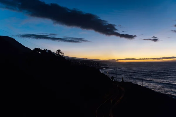 Voo acima das ondas oceânicas de frente para o belo pôr-do-sol e montanhas no horizonte . — Fotografia de Stock