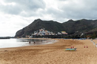 Altın kumun, palmiye ağaçlarının, güneş panjurlarının tepesinden bak. bulutlu hava