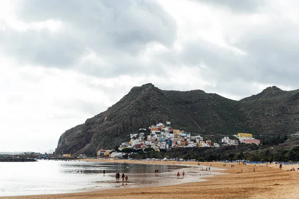 Altın kumun, palmiye ağaçlarının, güneş panjurlarının tepesinden bak. bulutlu hava
