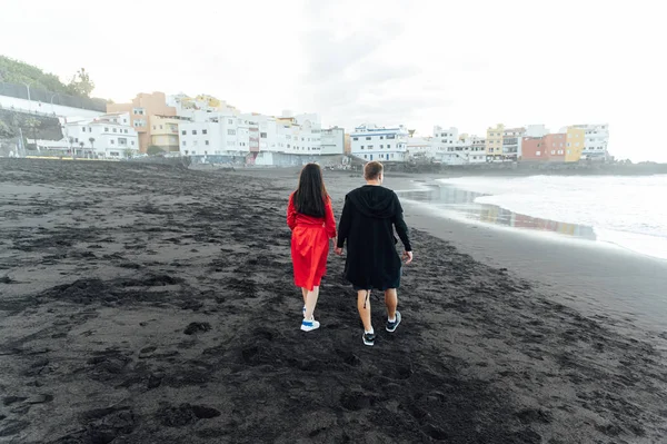 Couple amoureux marchant sur la plage près de l'océan puissant avec le coucher de soleil à Puerto de la cruz — Photo