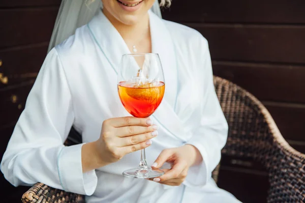 Сексуальная женщина, держащая стакан с коктейлем с аперолом и улыбающаяся на солнце — стоковое фото