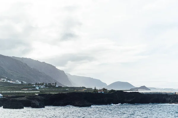 Fantasticamente belo pôr do sol na costa norte de Tenerife, uma praia com pedras e areia preta . — Fotografia de Stock