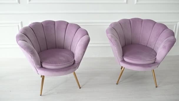 schöne und bequeme rosa Sessel stehen in einem geräumigen Raum in der Nähe der Wand.