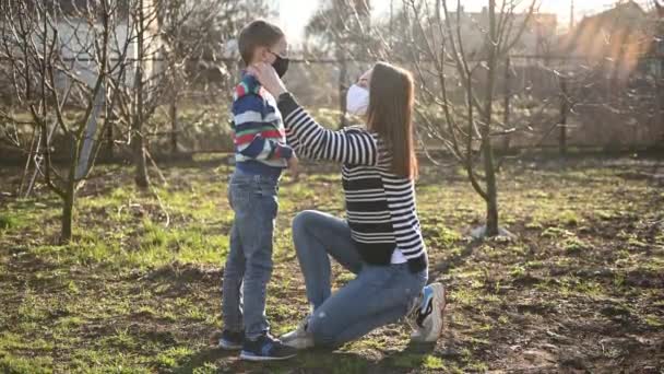 Vårdande mor sätter sin son på en mask för att skydda mot virus — Stockvideo