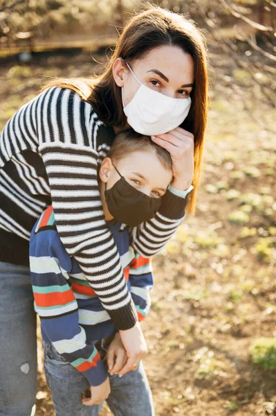 Caring mother hugs a masked child to protect him from the virus — Stock Photo, Image