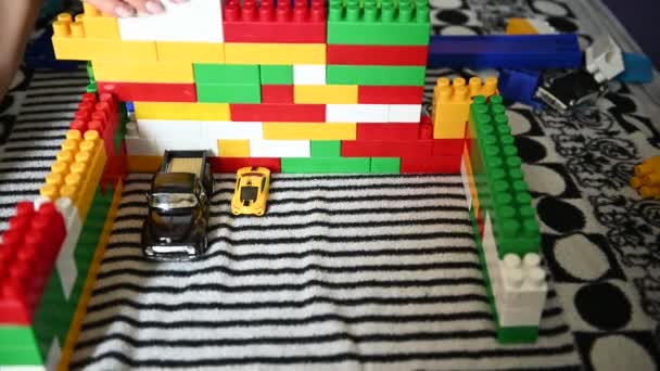 Niño feliz jugando en los bloques de colores en un sofá a rayas — Vídeo de stock