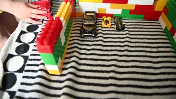 Niño feliz jugando en los bloques de colores en un sofá a rayas — Vídeo de stock