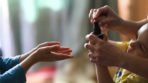 Mãe pulveriza um spray anti-séptico em suas mãos para seus filhos para desinfectar — Vídeo de Stock