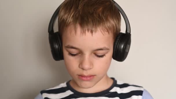 Έφηβος αγόρι γραπτών μηνυμάτων χρησιμοποιώντας smartphone ακούγοντας μουσική φορώντας ακουστικά — Αρχείο Βίντεο