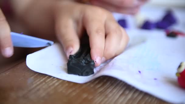 Een jongetje speelt plasticine. Mam helpt hem soms. — Stockvideo