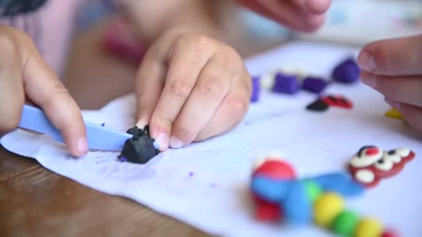 Un petit garçon joue de la plasticine. Maman l'aide parfois. — Video