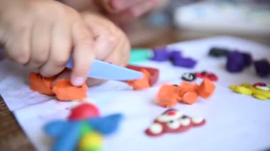 Küçük bir çocuk plastikçilik oynuyor. Annem bazen ona yardım eder.