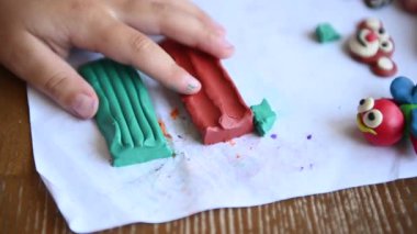 Küçük bir çocuk plastikçilik oynuyor. Annem bazen ona yardım eder.