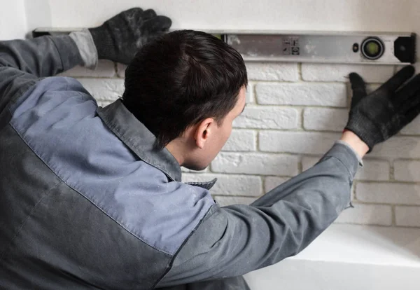 Professionele werker een tegel op muur lijmen — Stockfoto