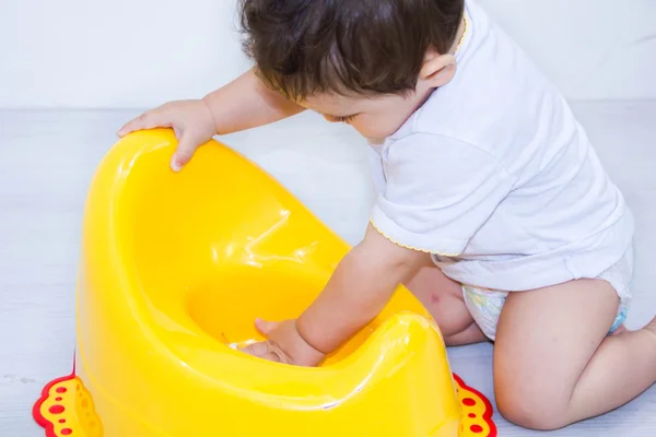 Infant child baby boy toddler play with potty toilet stool pot on a white background — Stock Photo, Image